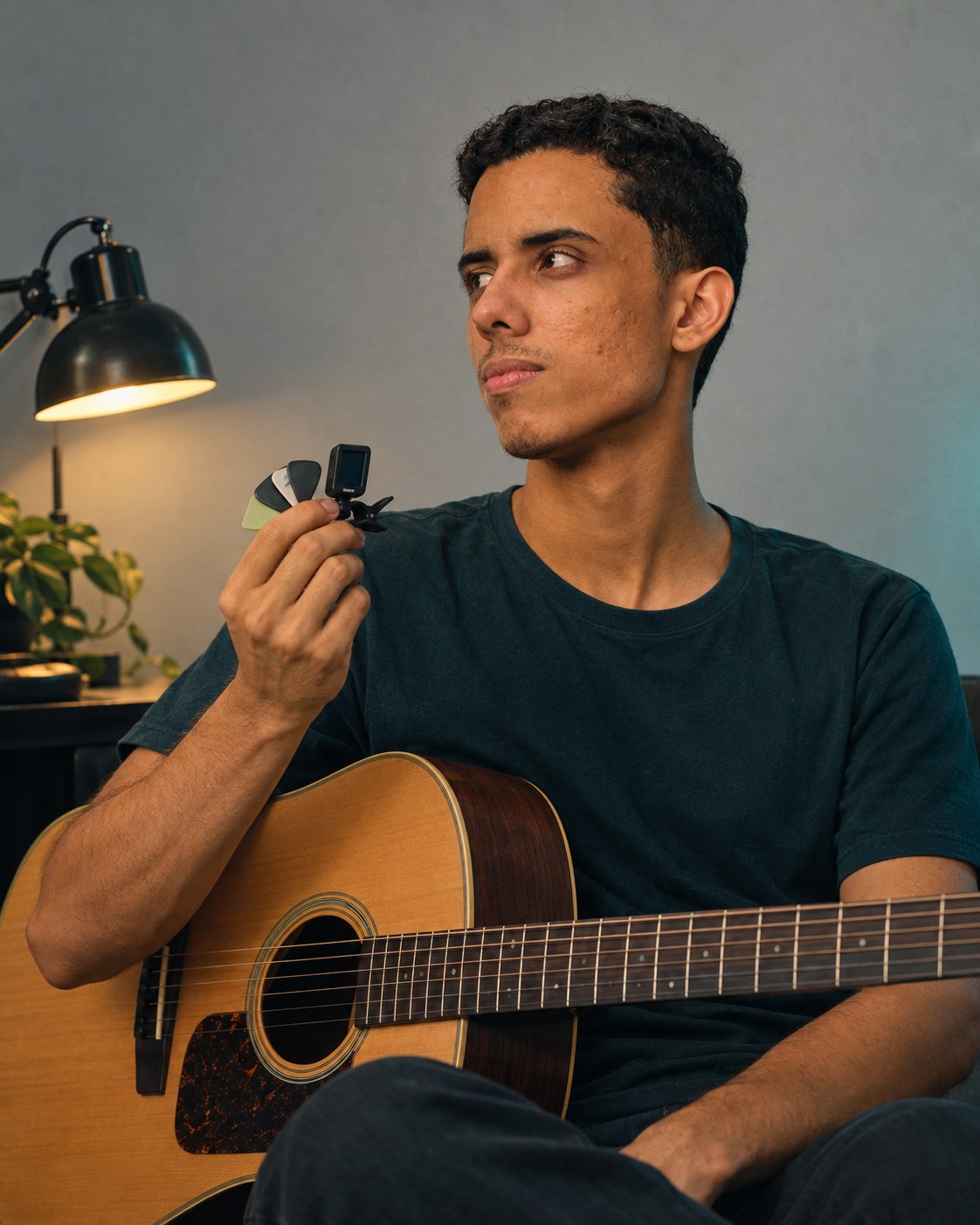 Patrick German segurando palhetas e afinador